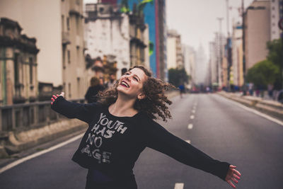 Side view of young woman standing in city