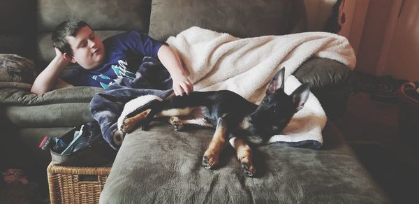 Full length of boy sleeping on sofa at home