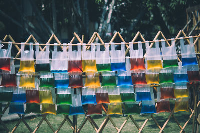 Multi colored umbrellas on fence by water