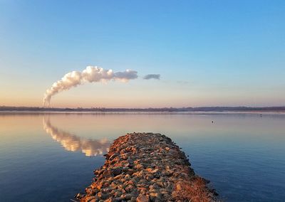 Smoke emitting from factory against clear sky