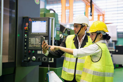 Side view of engineers working at factory