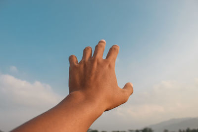 Left hand with blue sky background