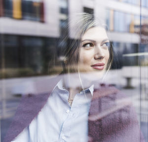 Smiling young woman looking out of window
