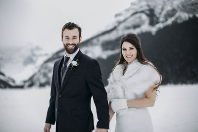 Caucasian couple in wedding attire just married in winter in mountains