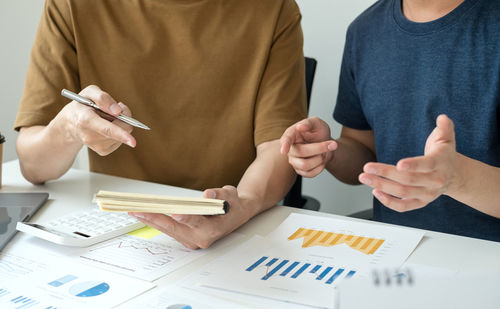 Midsection of business people working on table