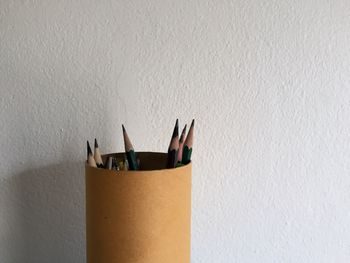 Close-up of pencil on table against wall