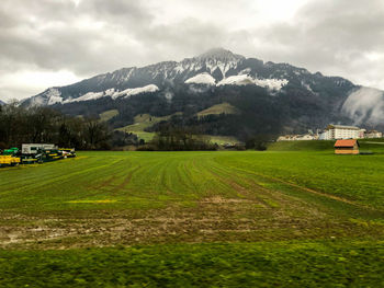 Scenic view of field and mountains against sky