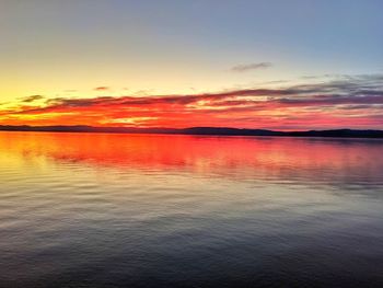 Scenic view of sea against dramatic sky during sunset