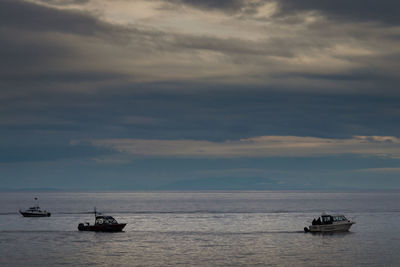 Boat sailing in sea against sky during sunset