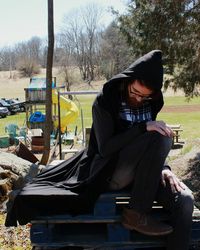 Man sitting on seat against sky
