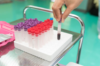 Cropped image of hand keeping blood sample in test tube rack