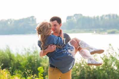 Portrait of friends standing by lake