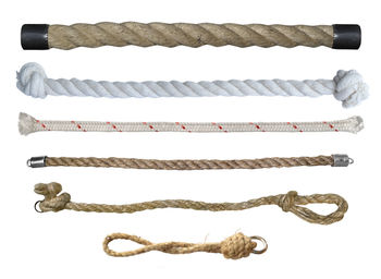 Close-up of rope on table against white background