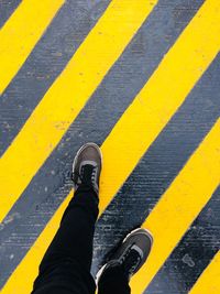 Low section of person standing on zebra crossing 