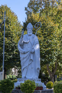 Low angle view of statue against trees