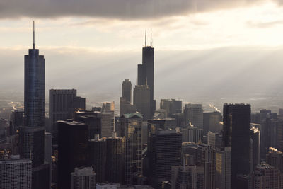 Skyscrapers in city against cloudy sky