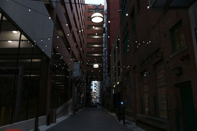 Illuminated corridor in city at night