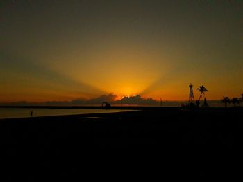 Scenic view of silhouette beach against sky during sunset