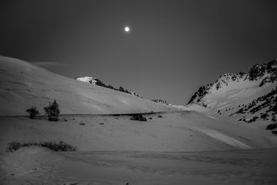 Scenic view of snowcapped mountains against sky at night