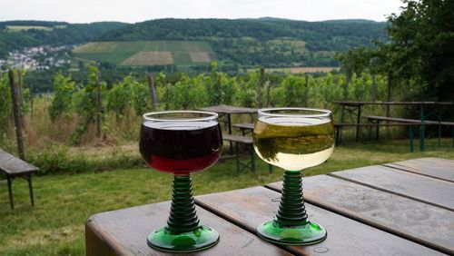 Close-up of wine glasses on table against mountains