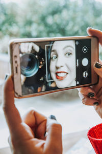 Portrait of woman photographing with mobile phone