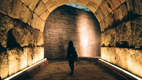 Rear view of silhouette man walking in tunnel