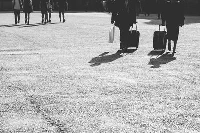 Low section of people walking on sidewalk in city