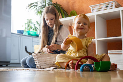 Low angle view of sisters playing with toys at home