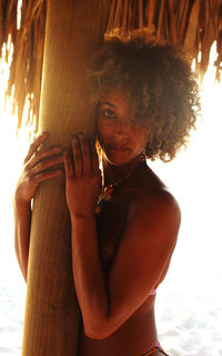 Portrait of beautiful woman standing on the beach in her bikini