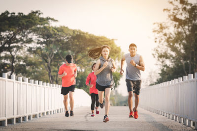 Rear view of people running on footpath