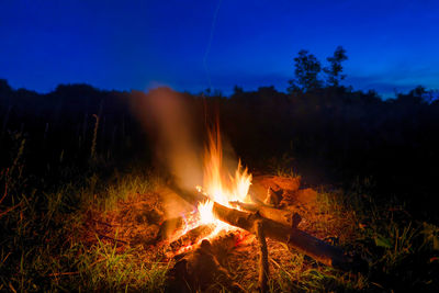 Bonfire on field against sky at night