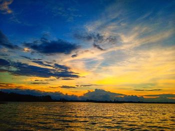 Scenic view of sea against dramatic sky during sunset