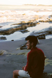 Side view of young man looking at sea