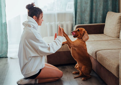 Man with dog sitting on sofa at home