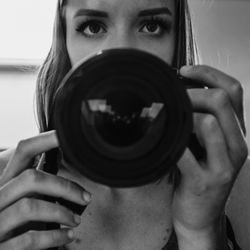 Close-up portrait of woman holding camera