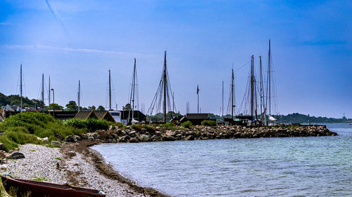 Sailboats sailing in sea against blue sky