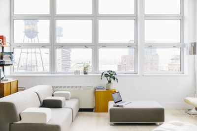 Furniture on hardwood floor against windows in modern startup office