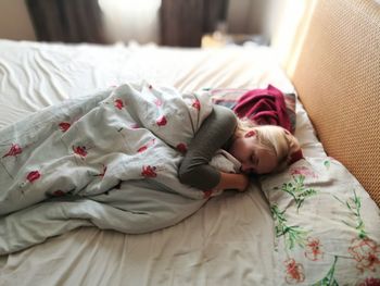 High angle view of woman sleeping on bed at home