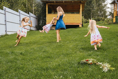 Rear view of women standing on grassy field