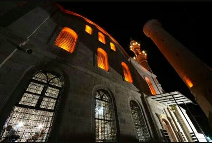 LOW ANGLE VIEW OF ILLUMINATED BUILDING AT NIGHT