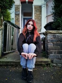 Portrait of beautiful woman standing against building