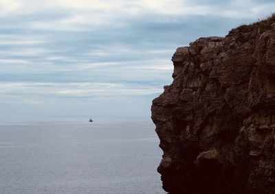 Rock formations by sea against sky