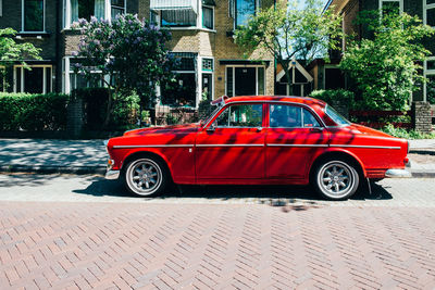 Vintage car on street against buildings in city