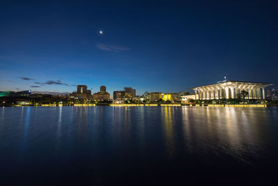 Illuminated tuanku mizan zainal abidin mosque by lake against sky at night