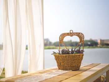 Close-up of wicker basket on table against clear sky