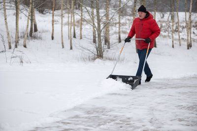 Low section of man skiing on snow covered field