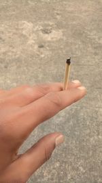 Close-up of hand holding cigarette