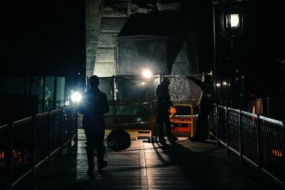 People walking on brooklyn bridge at night