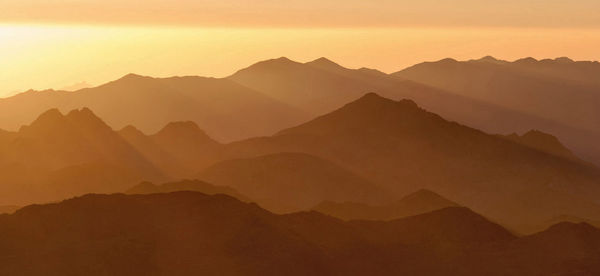 Scenic view of silhouette mountains against sky during sunset