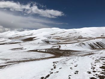 Snow covered landscape against sky